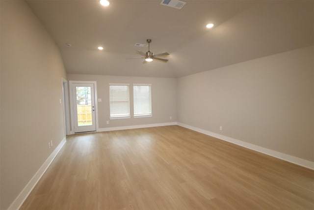 empty room with lofted ceiling, light hardwood / wood-style flooring, and ceiling fan