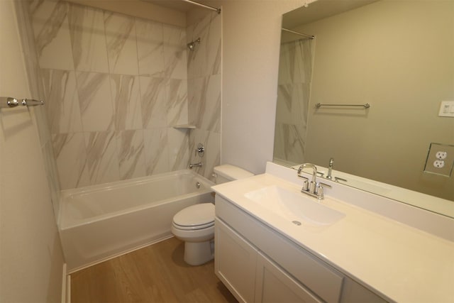 full bathroom with hardwood / wood-style flooring, vanity, tiled shower / bath combo, and toilet