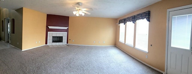 unfurnished living room featuring a fireplace, carpet floors, and ceiling fan