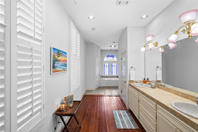 bathroom featuring a washtub, hardwood / wood-style flooring, and vanity