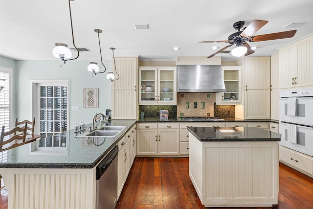 kitchen featuring sink, ventilation hood, hanging light fixtures, kitchen peninsula, and stainless steel appliances