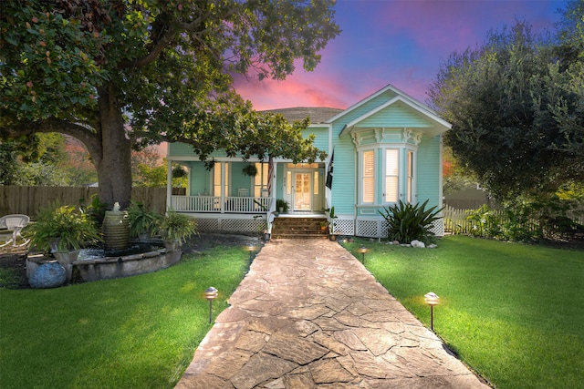 view of front of property featuring a yard and covered porch