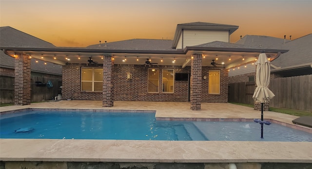 pool at dusk with a patio area