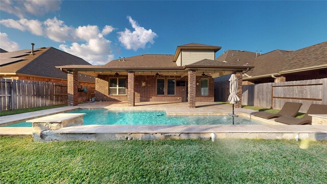 view of pool with ceiling fan, a lawn, and a patio