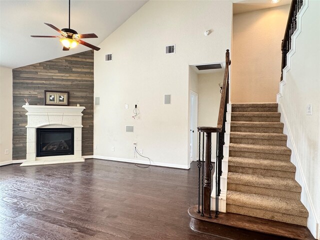 unfurnished living room with ceiling fan, dark hardwood / wood-style floors, and high vaulted ceiling