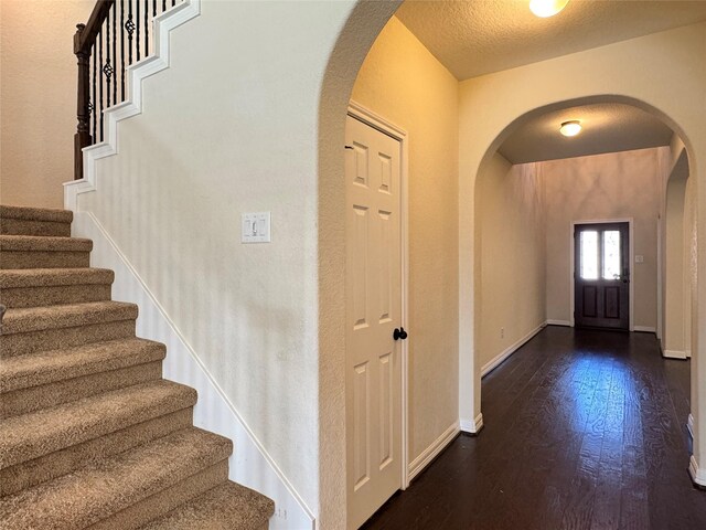 entryway with a textured ceiling and dark hardwood / wood-style floors