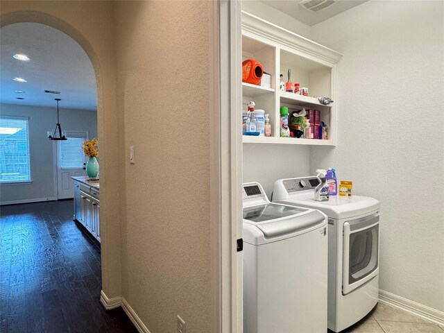 laundry room with washer and clothes dryer and wood-type flooring