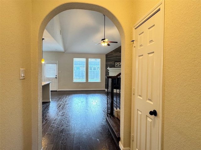 interior space featuring ceiling fan, vaulted ceiling, and dark hardwood / wood-style floors