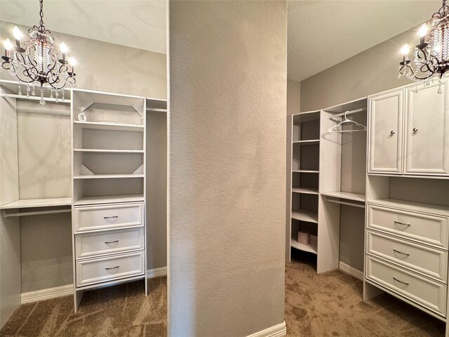 spacious closet featuring dark carpet and a notable chandelier