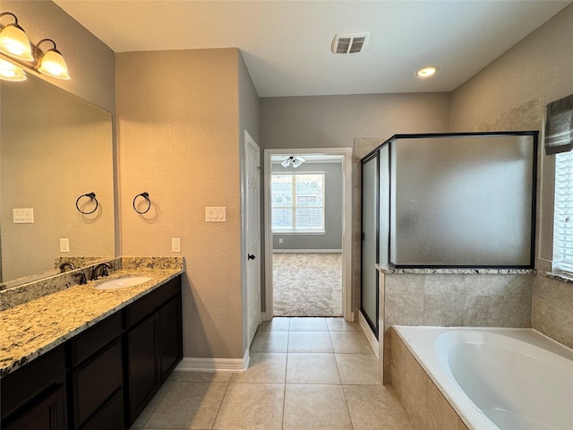 bathroom featuring tile patterned flooring, shower with separate bathtub, and vanity