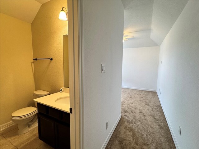 bathroom with ceiling fan, vanity, vaulted ceiling, and toilet