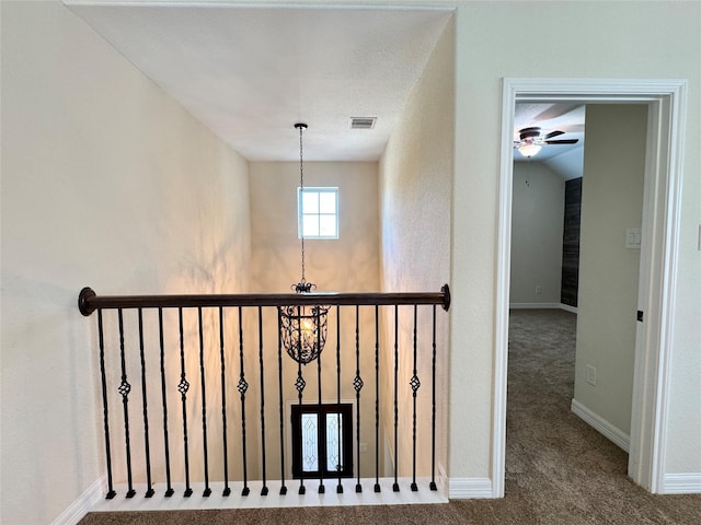 staircase with vaulted ceiling, a notable chandelier, and carpet flooring