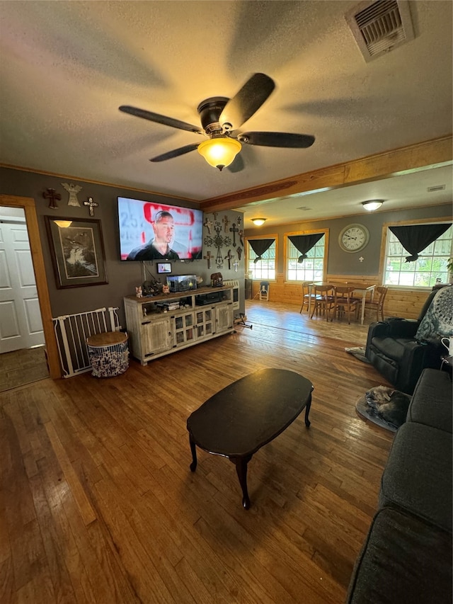 living room featuring a textured ceiling, hardwood / wood-style floors, and ceiling fan