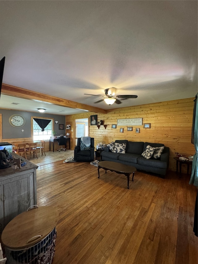 living room with wood walls, hardwood / wood-style flooring, and ceiling fan