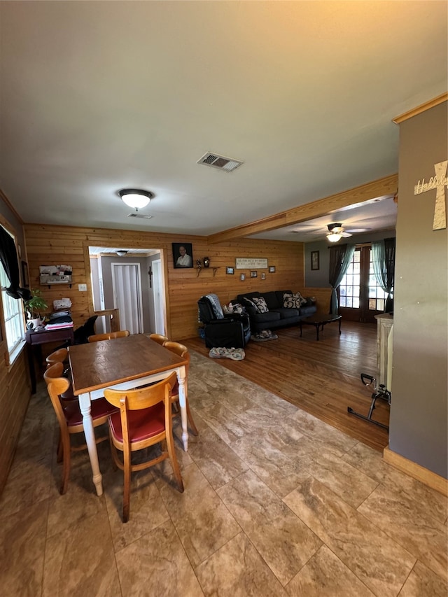 tiled dining space featuring wood walls