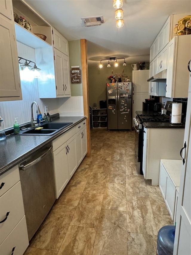 kitchen featuring sink, appliances with stainless steel finishes, light tile patterned floors, and white cabinetry