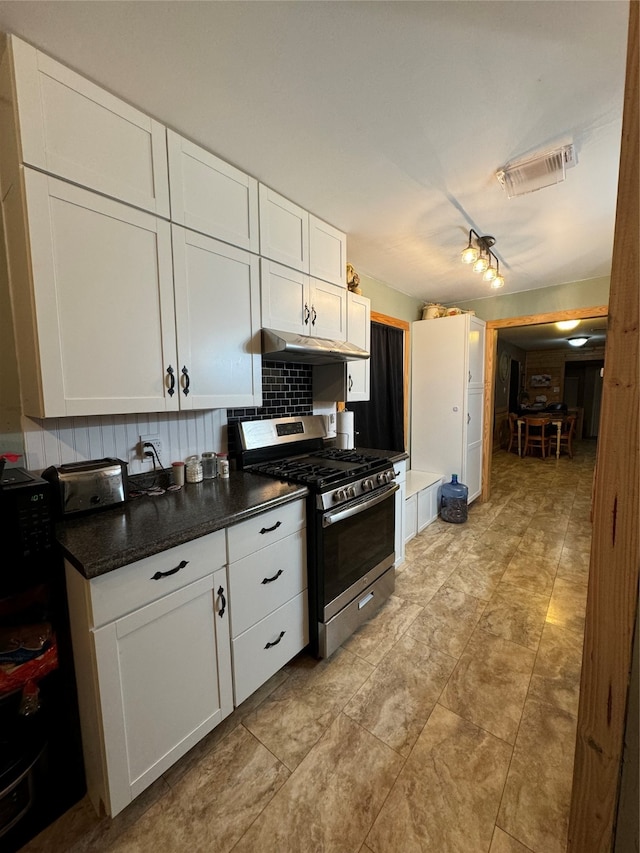 kitchen with white cabinetry, rail lighting, light tile patterned floors, backsplash, and stainless steel range with gas stovetop