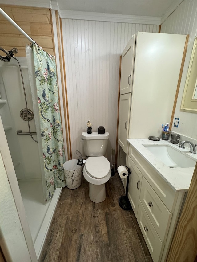 bathroom featuring walk in shower, toilet, vanity, hardwood / wood-style flooring, and ornamental molding