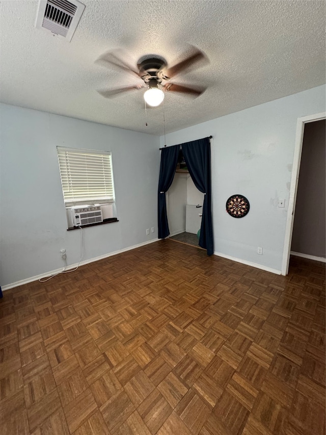 unfurnished room with cooling unit, ceiling fan, a textured ceiling, and dark parquet flooring