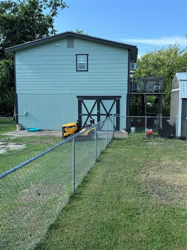 view of home's exterior with a deck, a shed, and a yard