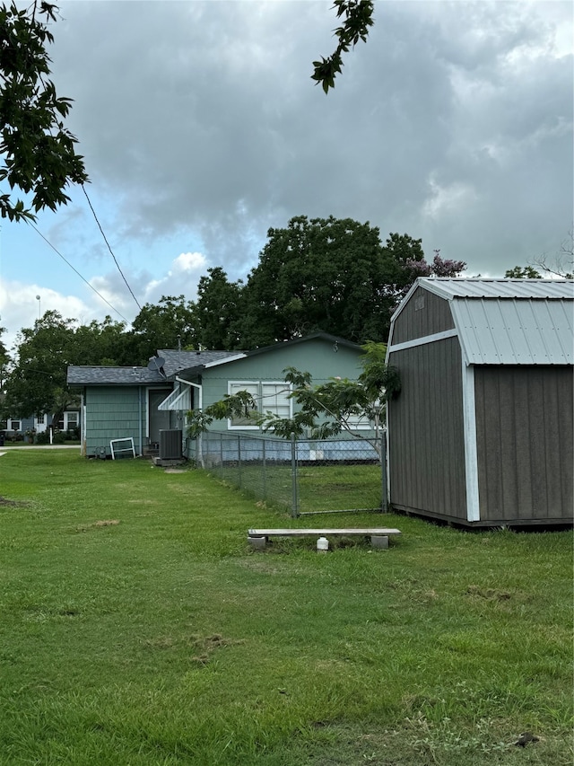 view of yard with central AC unit and a shed