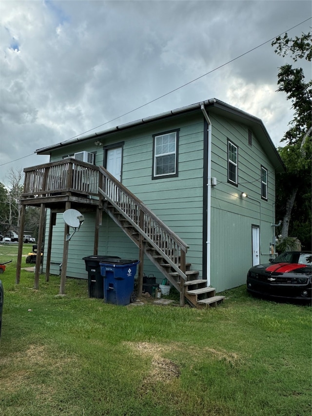 back of property with a deck and a yard