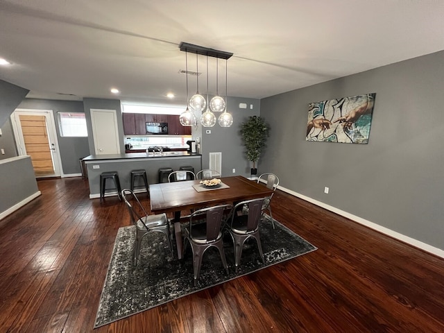 dining space with a chandelier and dark hardwood / wood-style floors