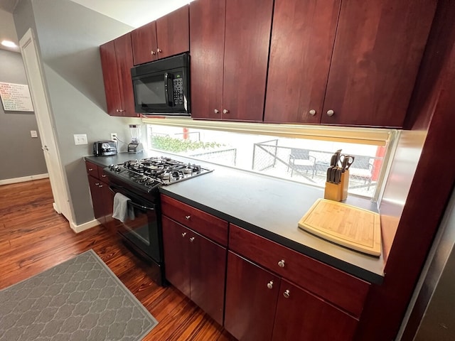 kitchen featuring dark hardwood / wood-style flooring and black appliances