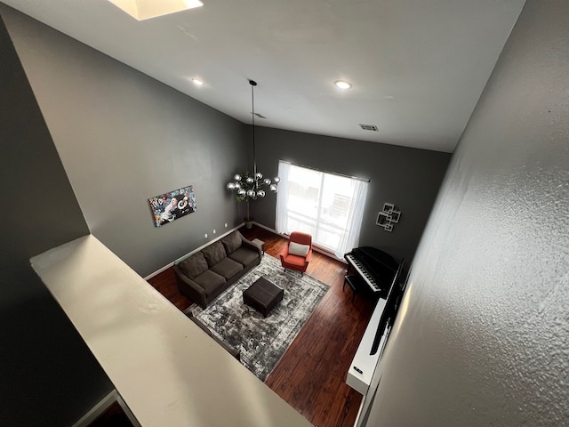 unfurnished living room with a notable chandelier, hardwood / wood-style flooring, and vaulted ceiling