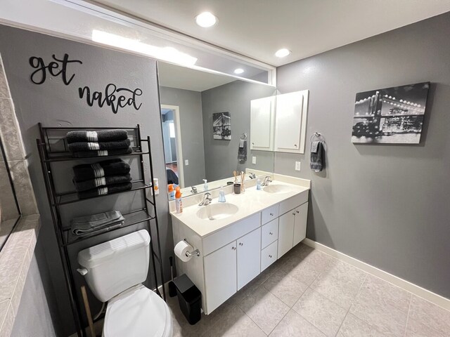 bathroom with tile patterned floors, toilet, and dual bowl vanity