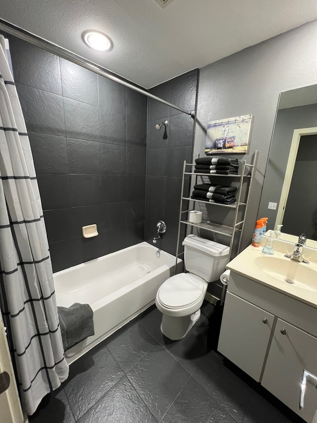 full bathroom with vanity, shower / bath combo with shower curtain, toilet, a textured ceiling, and tile patterned flooring