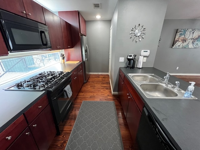 kitchen with dark hardwood / wood-style floors, black appliances, and sink