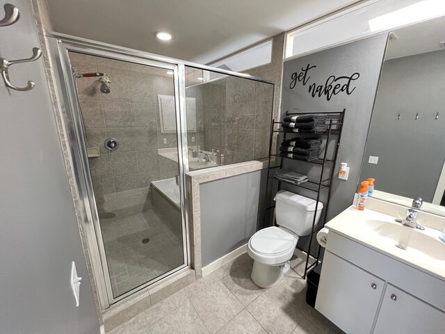 bathroom featuring a shower with door, vanity, toilet, and tile patterned floors