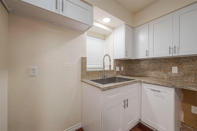 kitchen with sink, white cabinets, and tasteful backsplash