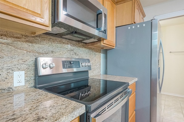 kitchen with appliances with stainless steel finishes, light tile patterned flooring, tasteful backsplash, and light stone countertops