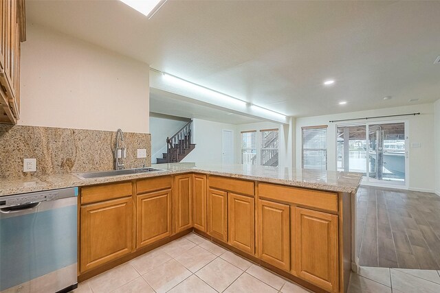 kitchen featuring sink, light tile patterned flooring, dishwasher, and kitchen peninsula