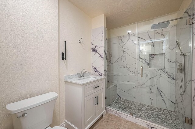 bathroom with a shower with shower door, vanity, a textured ceiling, and toilet