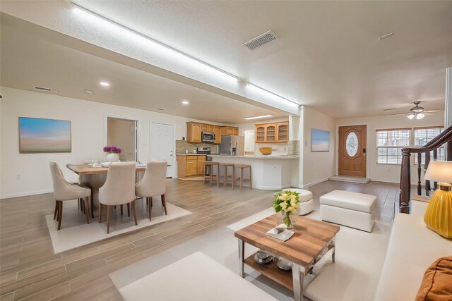 living room with ceiling fan and light hardwood / wood-style floors