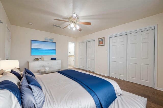 bedroom with multiple closets, wood-type flooring, and ceiling fan