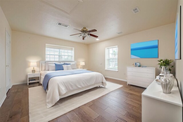 bedroom with multiple windows, hardwood / wood-style flooring, and ceiling fan