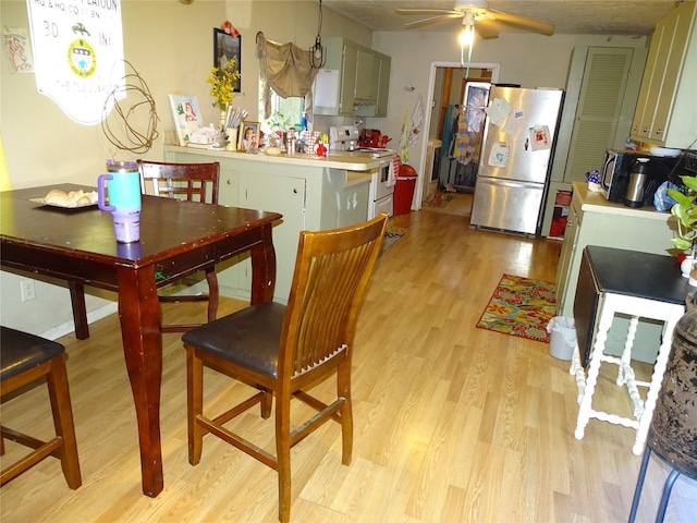 kitchen with white range with electric cooktop, stainless steel refrigerator, green cabinets, ceiling fan, and light hardwood / wood-style floors