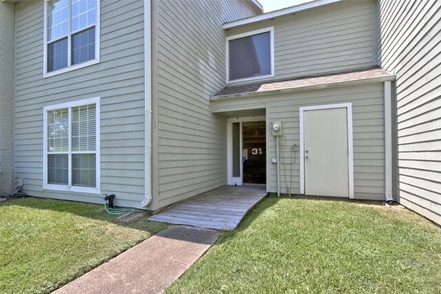 view of exterior entry featuring a yard