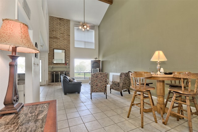 living room featuring high vaulted ceiling, plenty of natural light, light tile patterned floors, and a fireplace