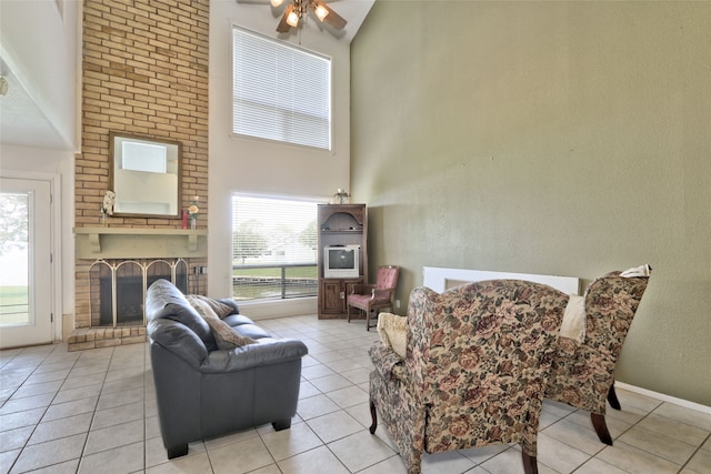 living room featuring a fireplace, high vaulted ceiling, light tile patterned floors, and ceiling fan