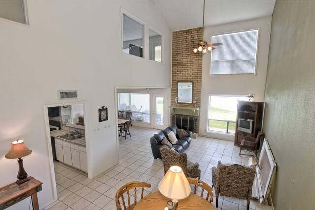 interior space featuring vaulted ceiling, sink, a brick fireplace, and ceiling fan