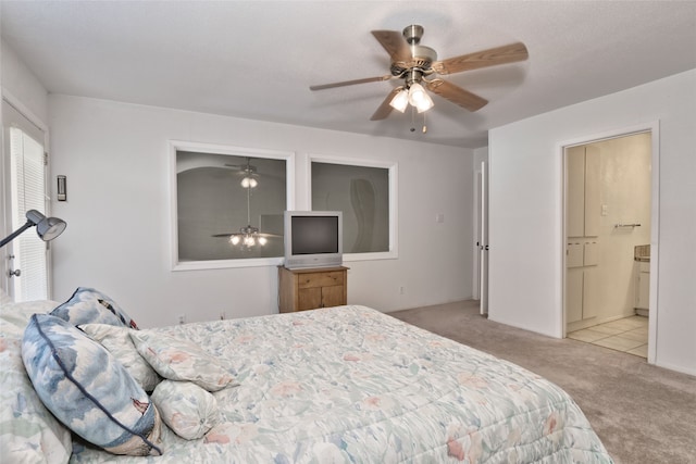 bedroom featuring connected bathroom, ceiling fan, and light colored carpet