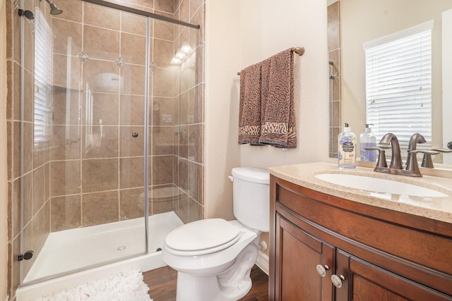 bathroom with toilet, vanity, walk in shower, and hardwood / wood-style flooring