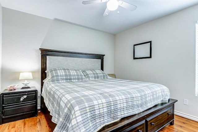 bedroom with baseboards, a ceiling fan, and wood finished floors