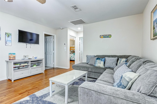 living area featuring light wood-type flooring, visible vents, and baseboards