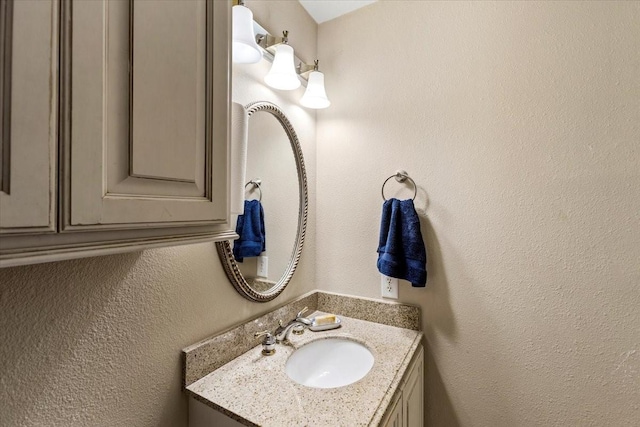 bathroom featuring a textured wall and vanity